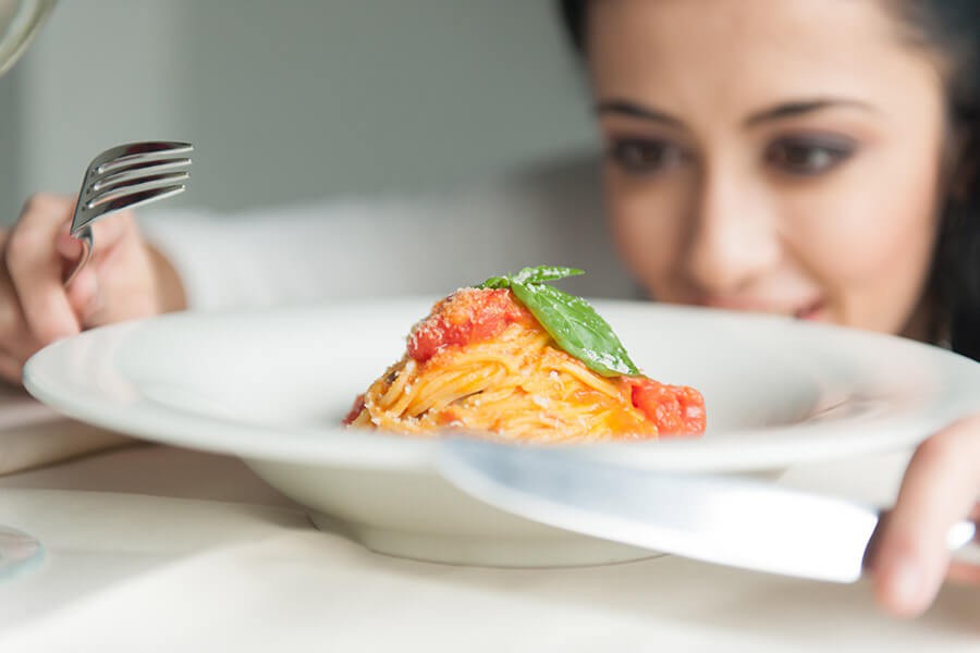 Ragazza ammira un piatto di pasta fumante